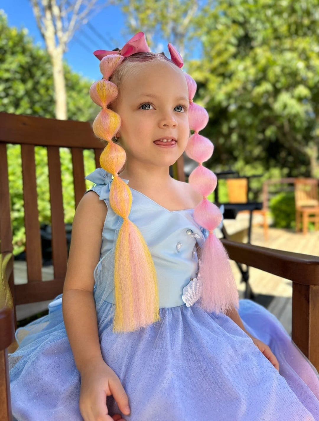 Criança fantasiada de sereia com penteado de festa